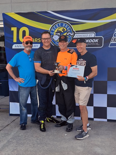 The Plan Z Motorsports team celebrating together after a podium finish